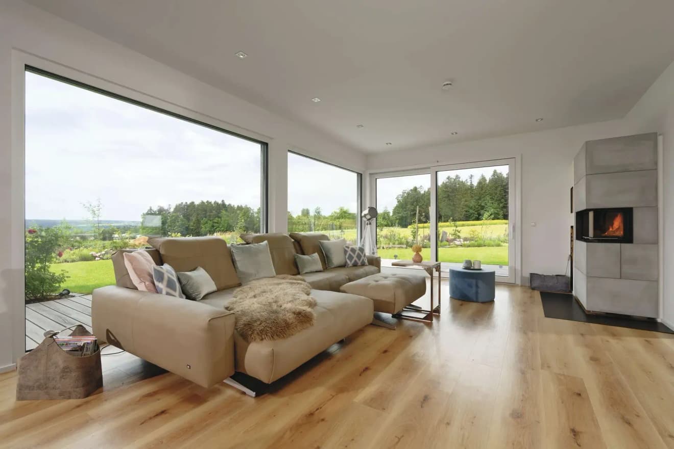Offenes Wohnzimmer mit Holzparkett und bodentiefen Fenstern